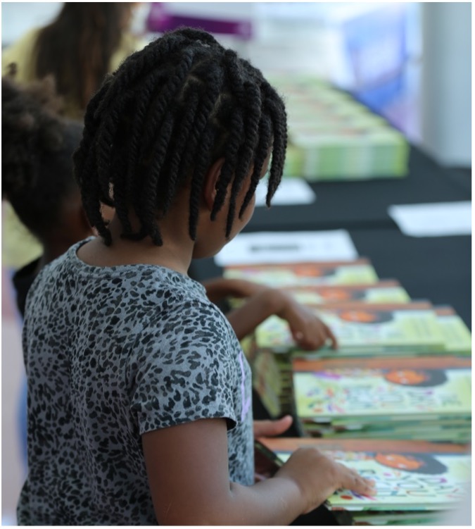 kids standing at a table with books